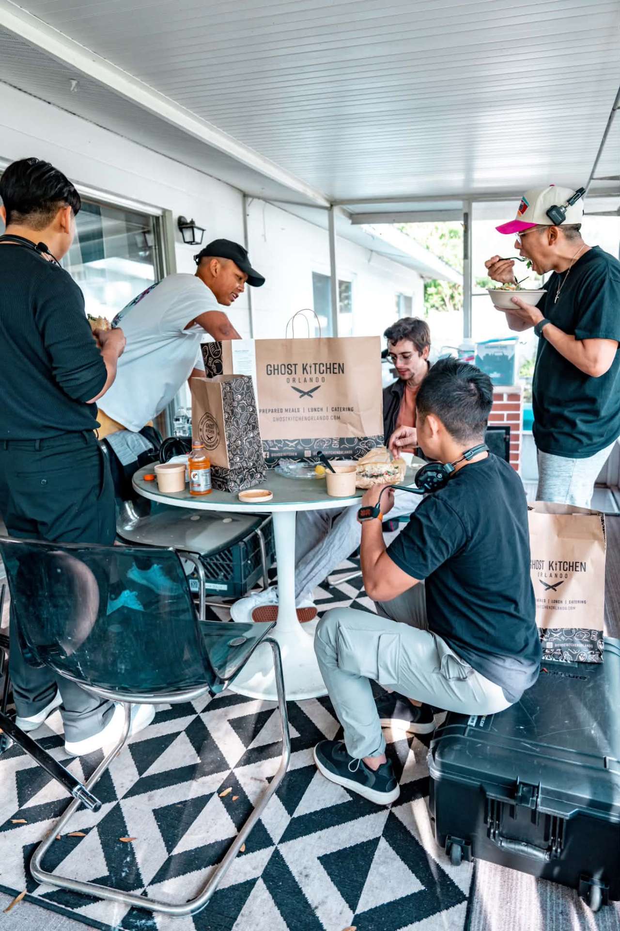 Production crew enjoying Ghost Kitchen Orlando catering sandwiches, bowls and bagged lunches around a table
